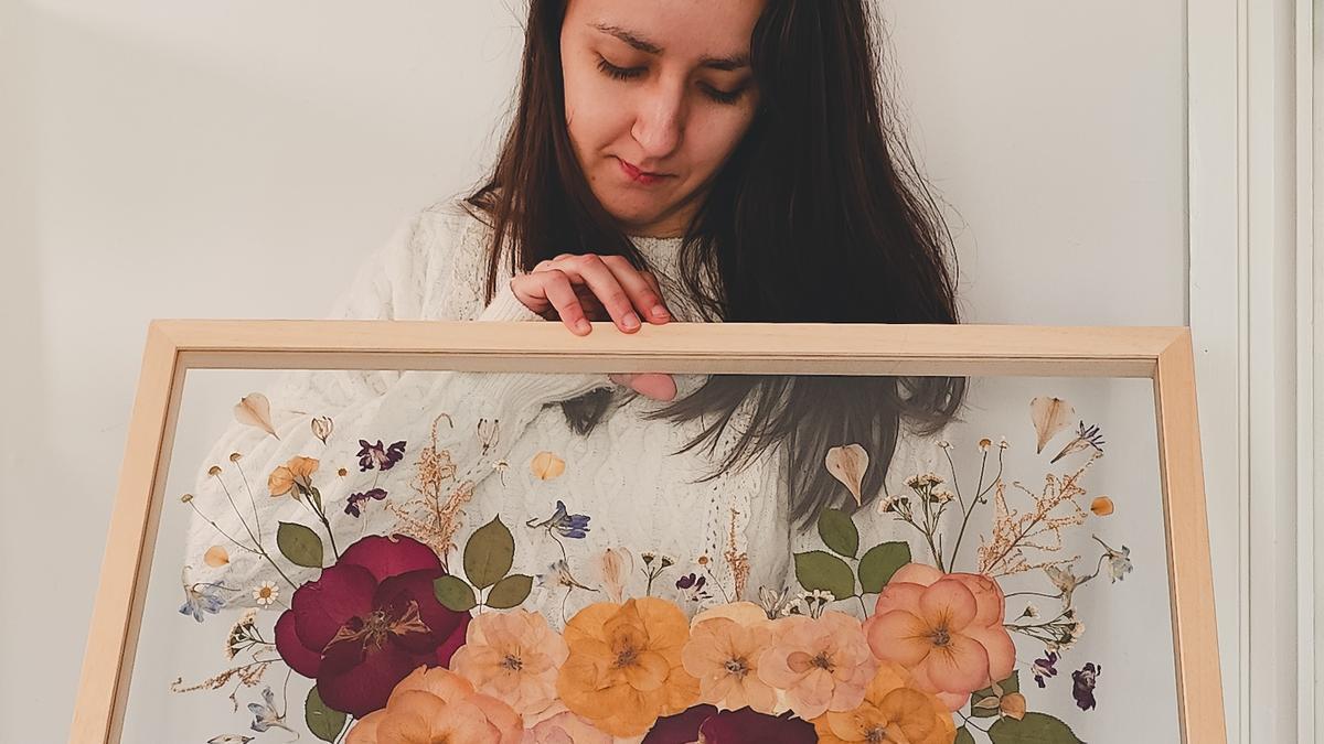 Laura Maquieira Estévez, con uno de los cuadros que ha elaborado usando las flores prensadas de un ramo.