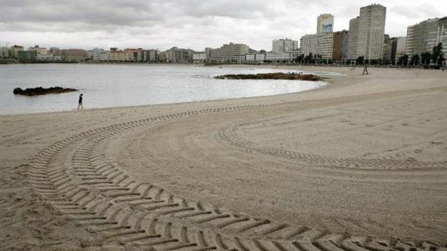 Una mujer pasea por la playa de Riazor un día nublado y frío del pasado mes de agosto. / cabalar