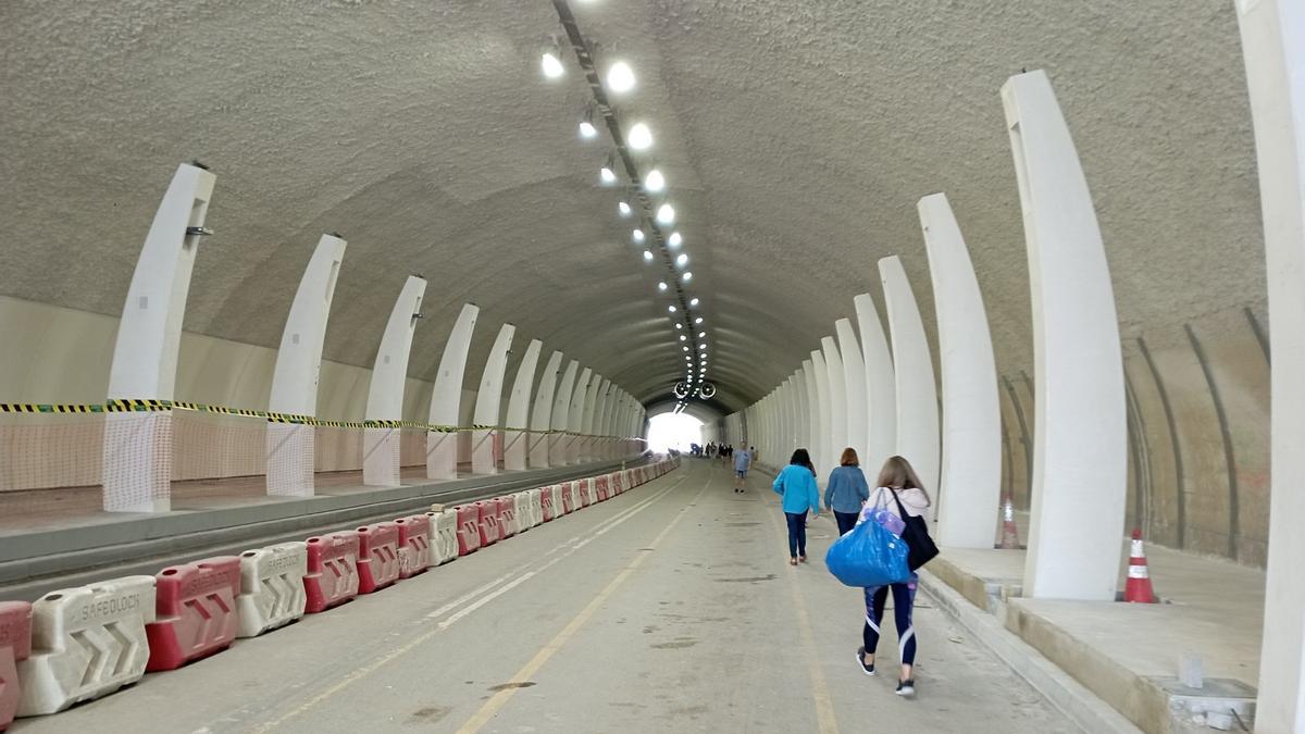 Peatones junto a las obras de insonorización del túnel de la Alcazaba, este mes.
