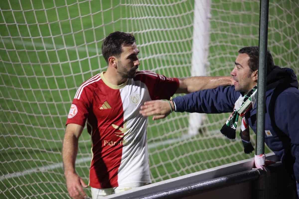 Un aficionado del Cacereño saluda a Joserra, bigoleador en Salamanca, tras el partido ante Unionistas.
