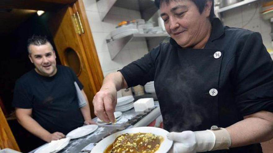 La cocinera del restaurante La Conda, de El Entrego, preparando un plato de cebolles rellenes.