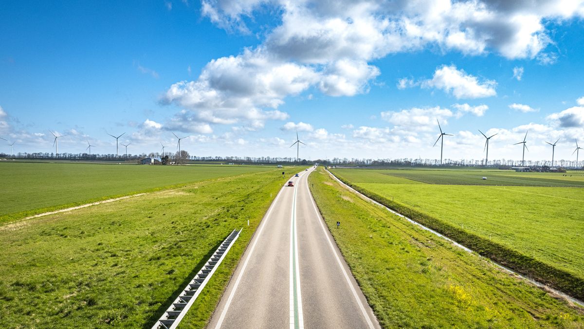 Carretera entre molinos de energía eólica