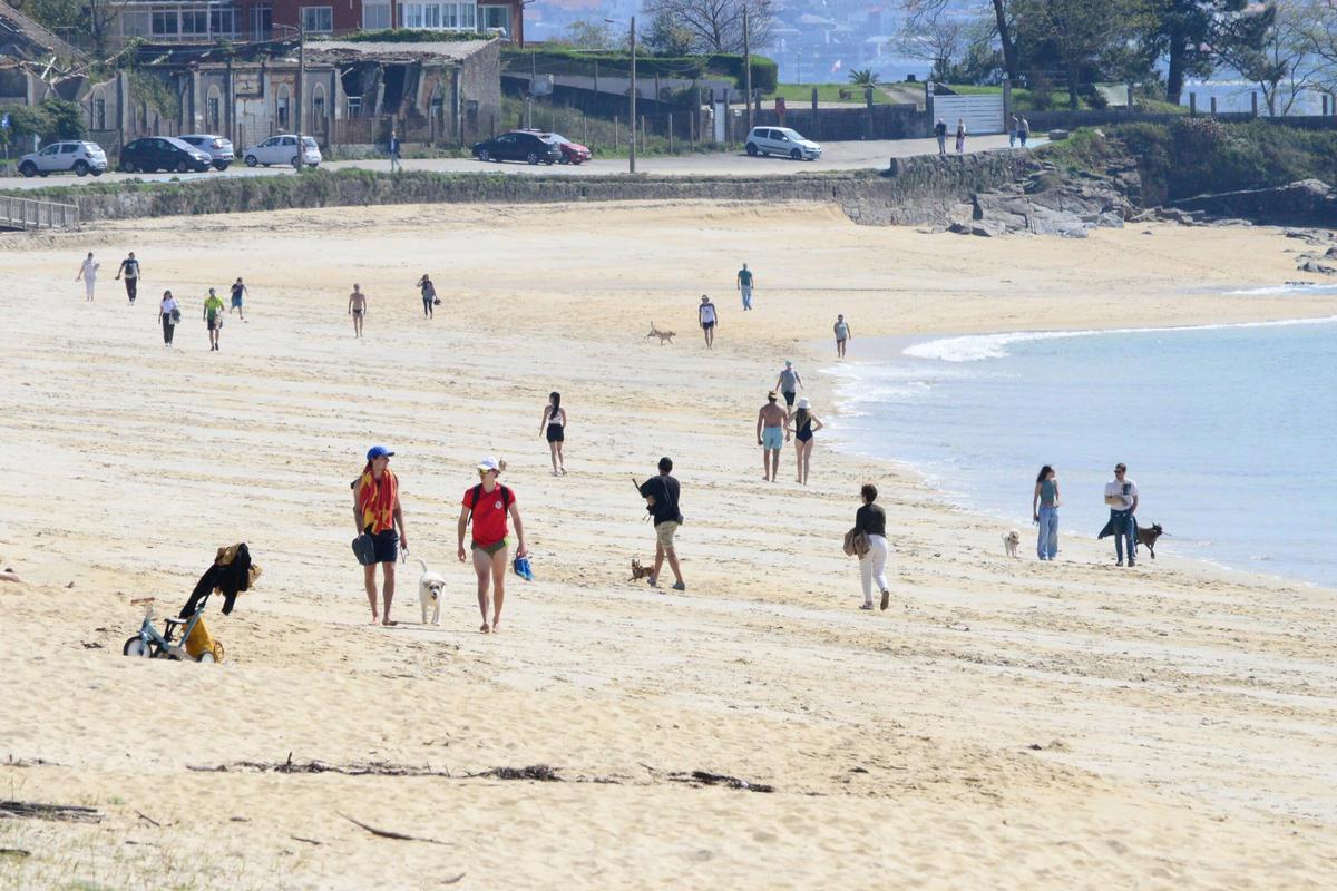 Vecinos disfrutando de la jornada primaveral de ayer en la playa canguesa de Rodeira.