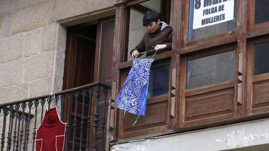 El delantal en el balcón, sinónimo de día libre en casa  |  Las mujeres están llamadas hoy a colgar un delantal en el balcón o en la ventana para visibilizar que en esa casa las mujeres se han tomado el día libre, y no cuidan de mayores ni de niños, no compran ni hacen la comida. Ayer en el casco viejo de Vigo, ya se podían ver los primeros mandiles colgados. Las mujeres dedican 4 horas y media a las tareas del hogar, ellos, dos horas menos.