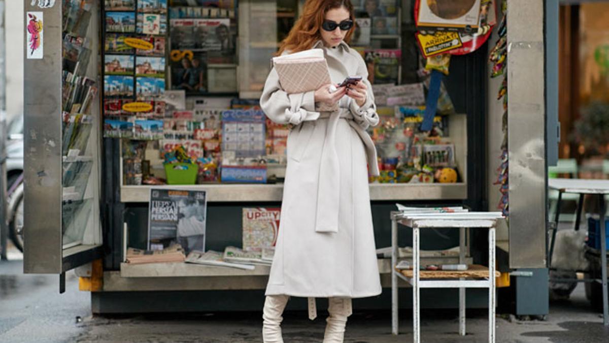 Mujer leyendo en quiosco durante la Semana de la Moda de Milán