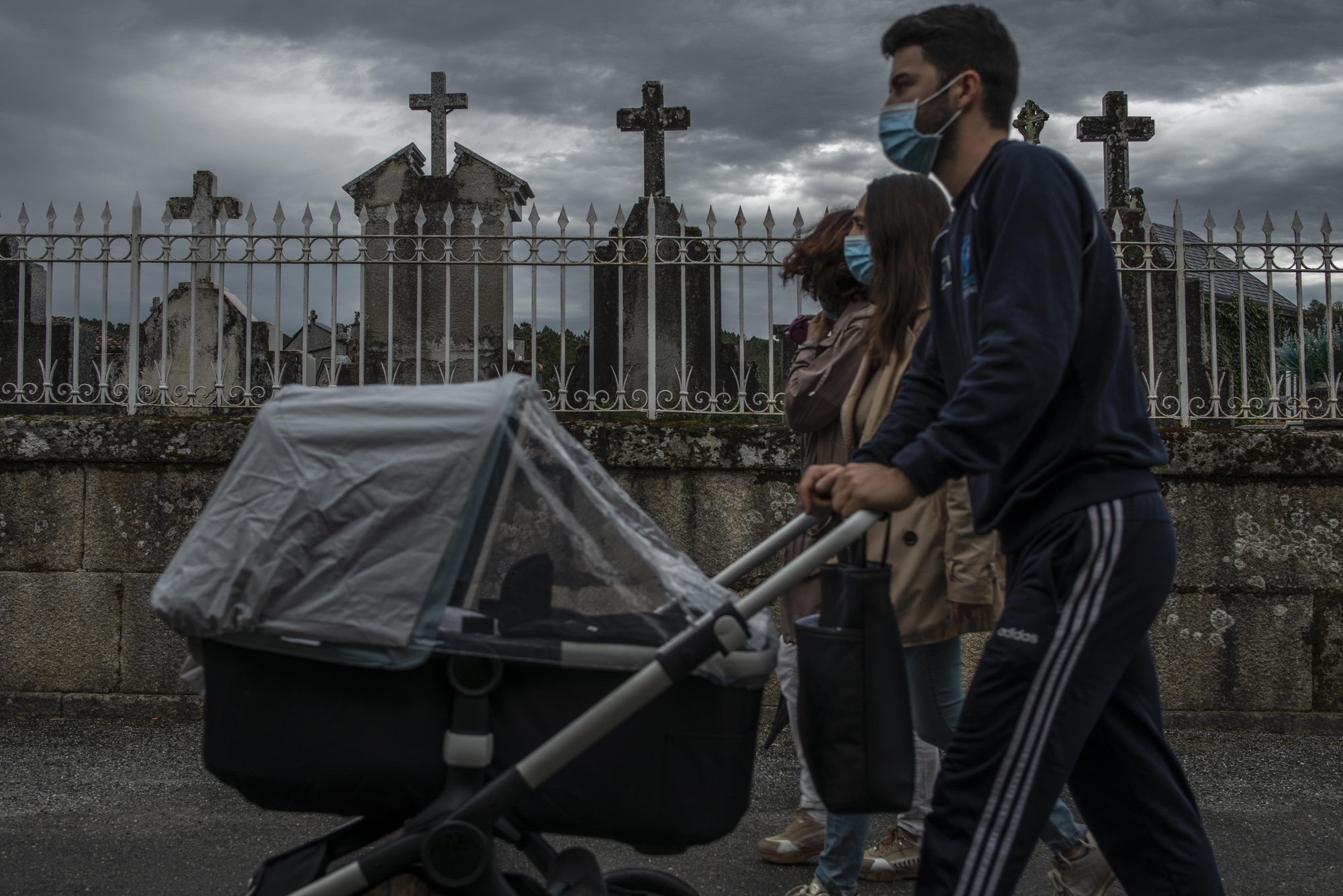 Una pareja pasea con un carro de bebé junto al cementerio, en 2021. // BRAIS LORENZO