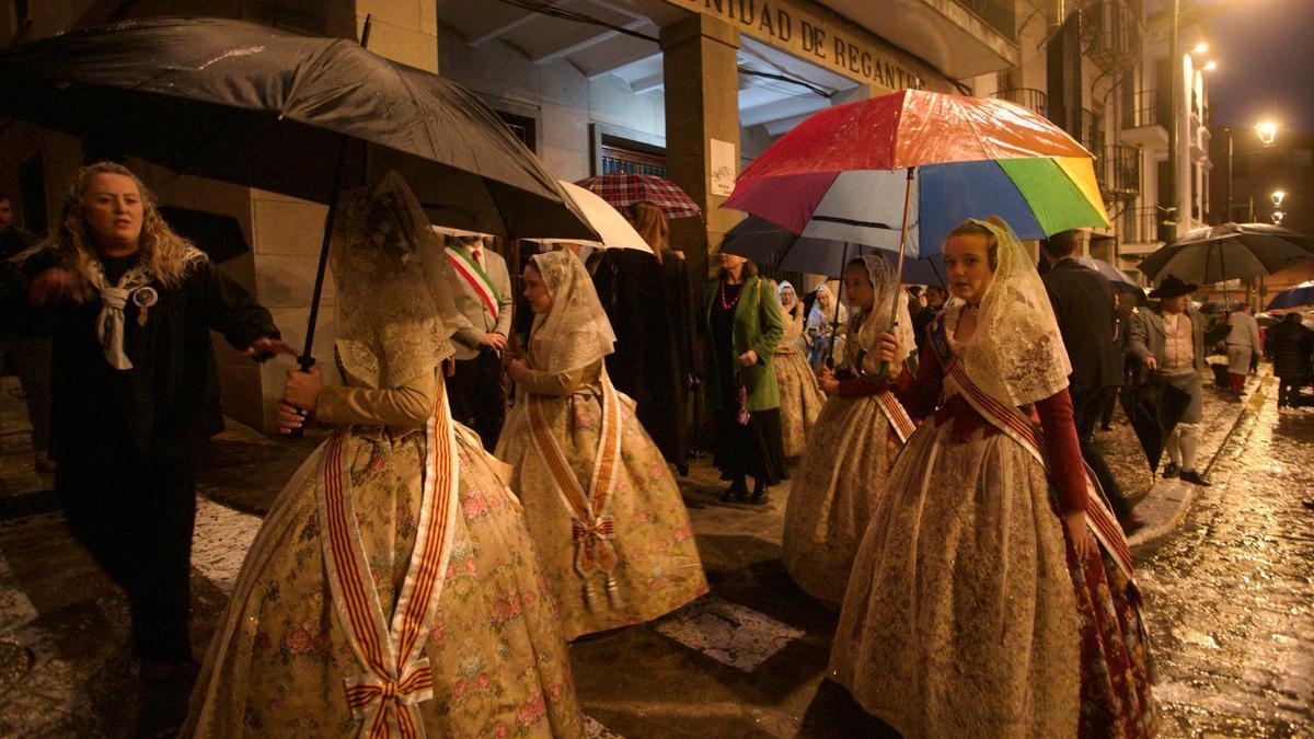 Unas falleras, con paraguas, antes de ofrendar en la iglesia.