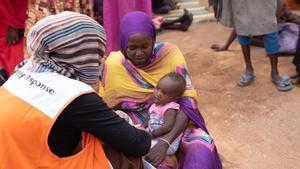 Cooperante de la organización World Vision para la desnutrición atiende a un niño en Sudán.