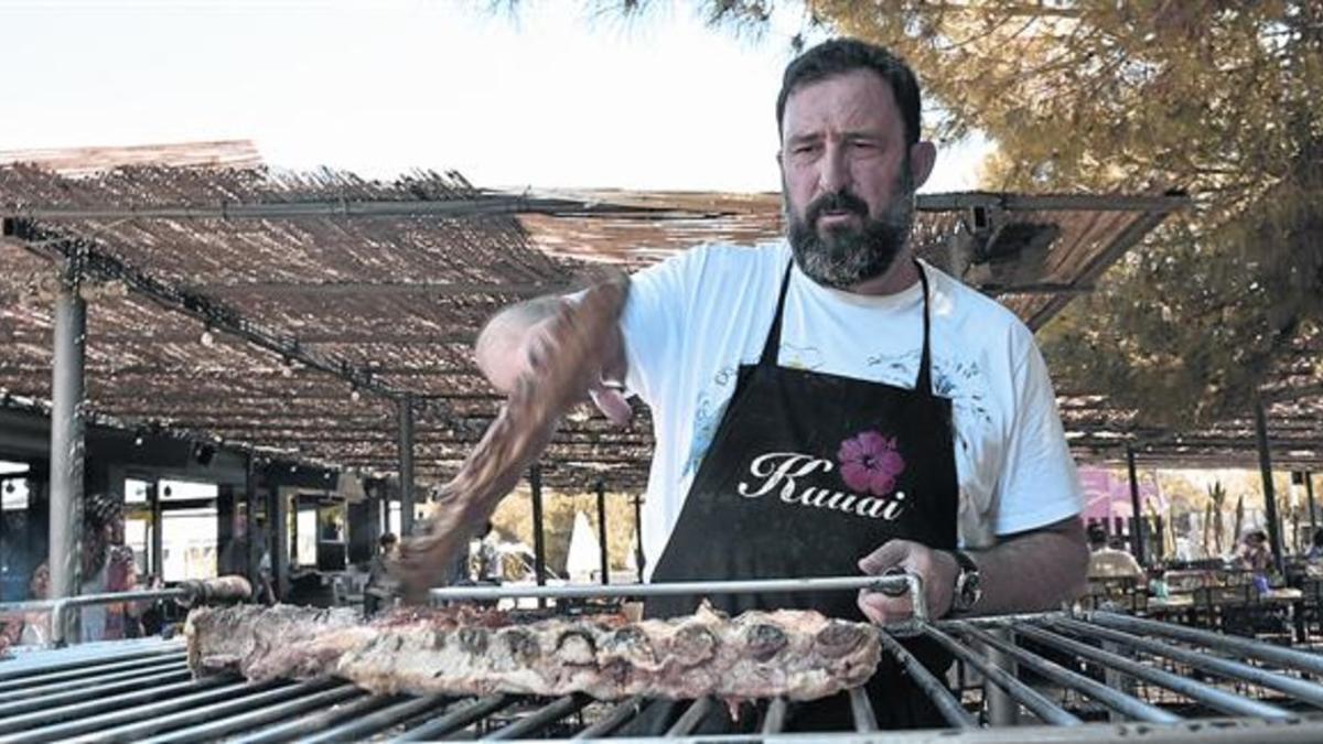 Óscar Manresa, con una pieza de carne en la barbacoa del restaurante Kauai, de Gavà.