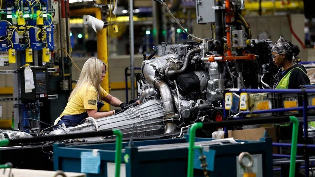 Una mujer afroamericana y otra blanca trabajan en una planta de General Motors en Flint, Michigan.