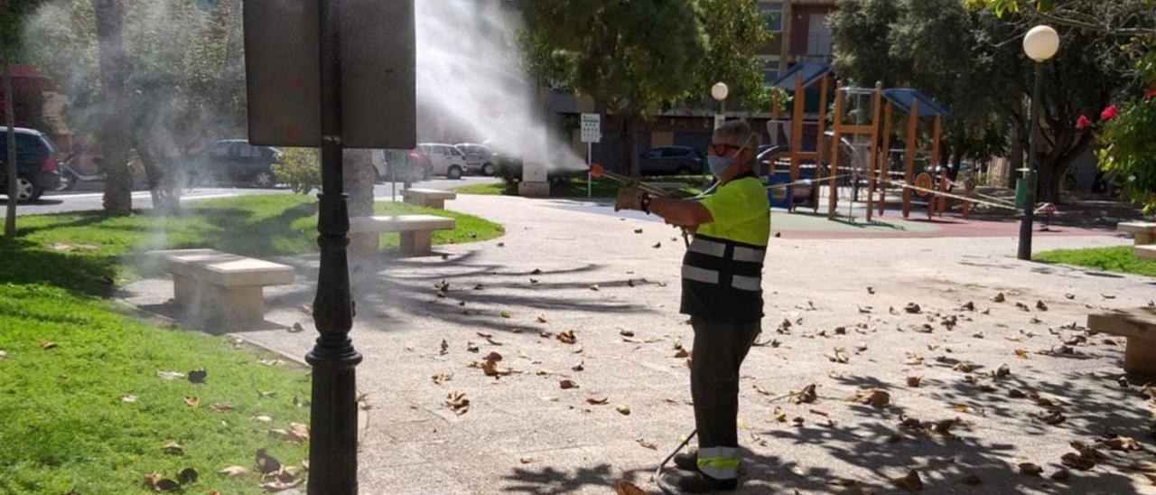 Un operario desinfecta un cartel en una de las zonas de recreo de San Vicente durante la pandemia. | INFORMACIÓN