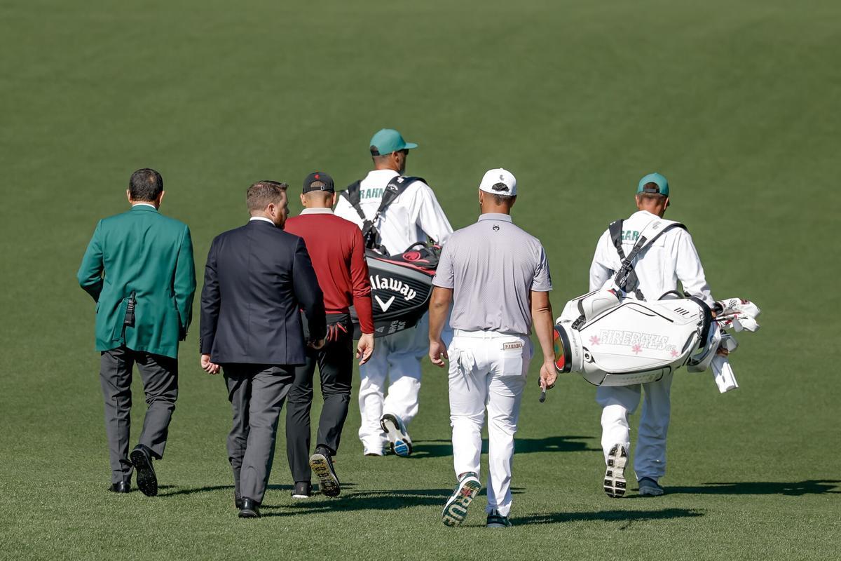 Un árbitro y un representante del comité de normas del Masters, le notifican a Sergio su aviso por mala conducta durante el juego