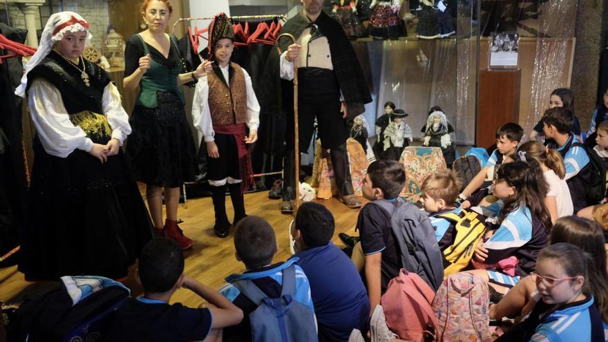 Catrocentos escolares coñecen a historia do traxe galego cas 200 bonecas de Magdalena Bringas