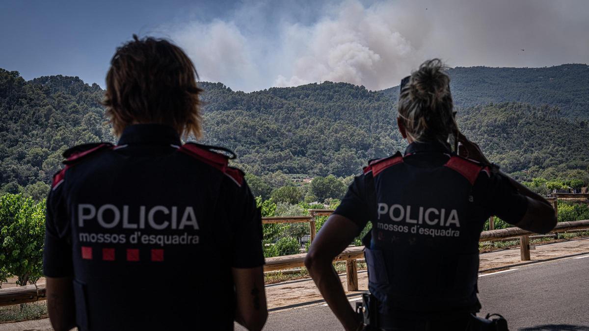 Dues agents dels Mossos d'Esquadra observen l'incendi de Sentmenat