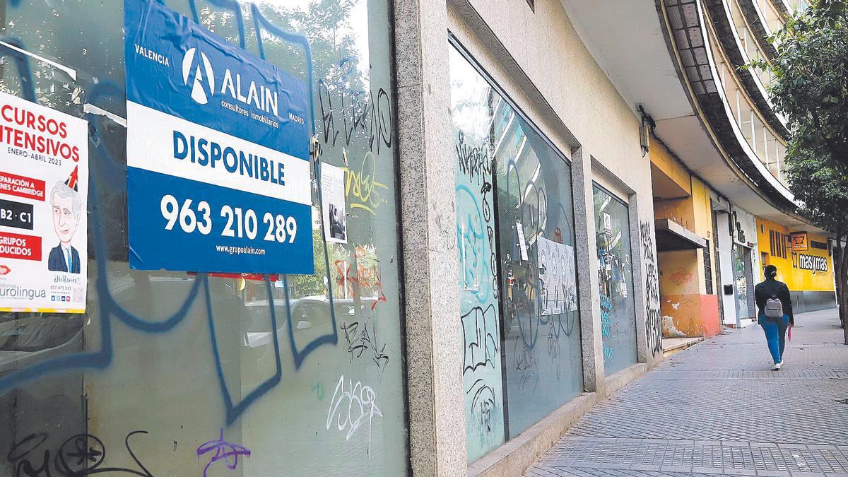 Un local cerrado en Ciudad Jardín, con carteles y pintadas.