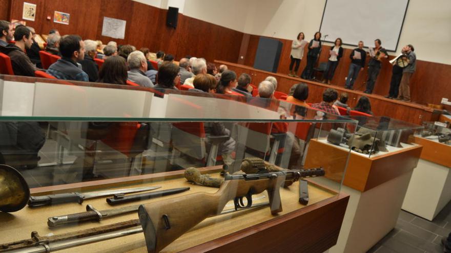 En primer terme, una vitrina amb armes de l´exposició sobre la guerra civil a la sala del Casino, durant l´actuació de la Berguedana de Folklore Total en l´acte d´homenatge a les víctimes del franquisme, dissabte 27 de febrer