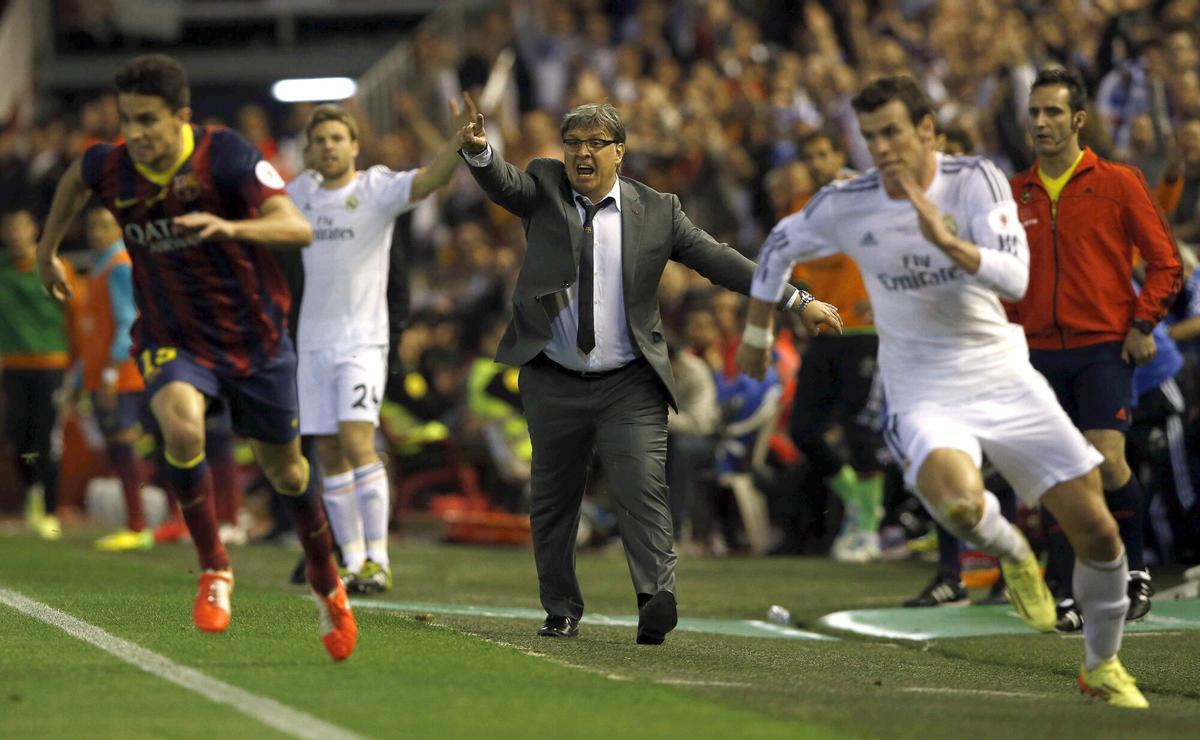 GRA516. VALENCIA, 16/04/2014.- El entrenador argentino del FC Barcelona Gerardo Martino (c) durante la jugada en la que el galés Gareth Bale (d), del Real Madrid, se escapa de Marc Bartra (i) para conseguir el segundo gol del equipo blanco, durante la final de la Copa del Rey que disputan esta noche en el estadio de Mestalla, en Valencia. EFE/Alberto Estévez. HORIZONTAL