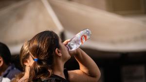 Una mujer toma agua para refrescarse y mitigar el calor durante la ola de calor de octubre en Canarias.