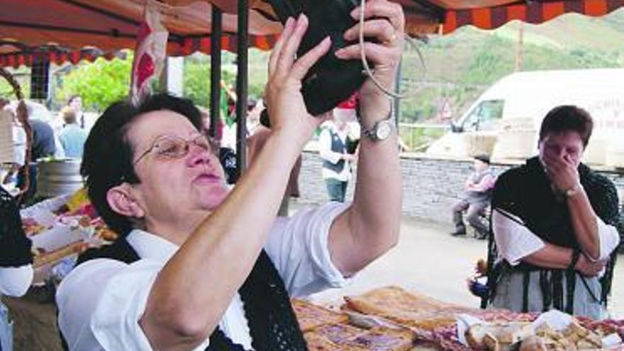 A la izquierda, María del Carmen Álvarez, catando el vino. A la derecha, un grupo de niños, en el taller de pisado de uva, ayer, durante la fiesta de Pesoz.