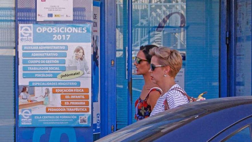 Dos mujeres pasan al lado de una academia que oferta cursos de formación para oposiciones.