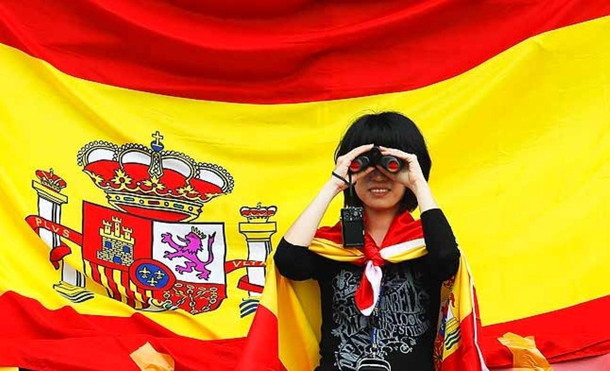 Una aficionada xinesa del pilot espanyol de Fórmula U, Fernando Alonso, usa els seus prismàtics per seguir la segona sessió d’entrenament al circuit internacional de Xangai (Xina).