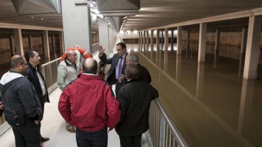 Un ingeniero explica a los representantes vecinales el funcionamiento del depósito, ayer.