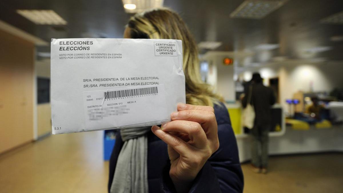 Una mujer enseña su voto por correo en las pasadas elecciones