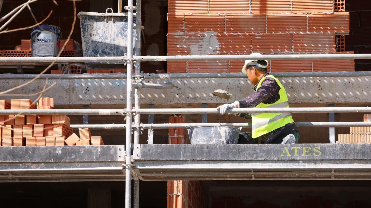 Un trabajador construyendo viviendas este año en València.