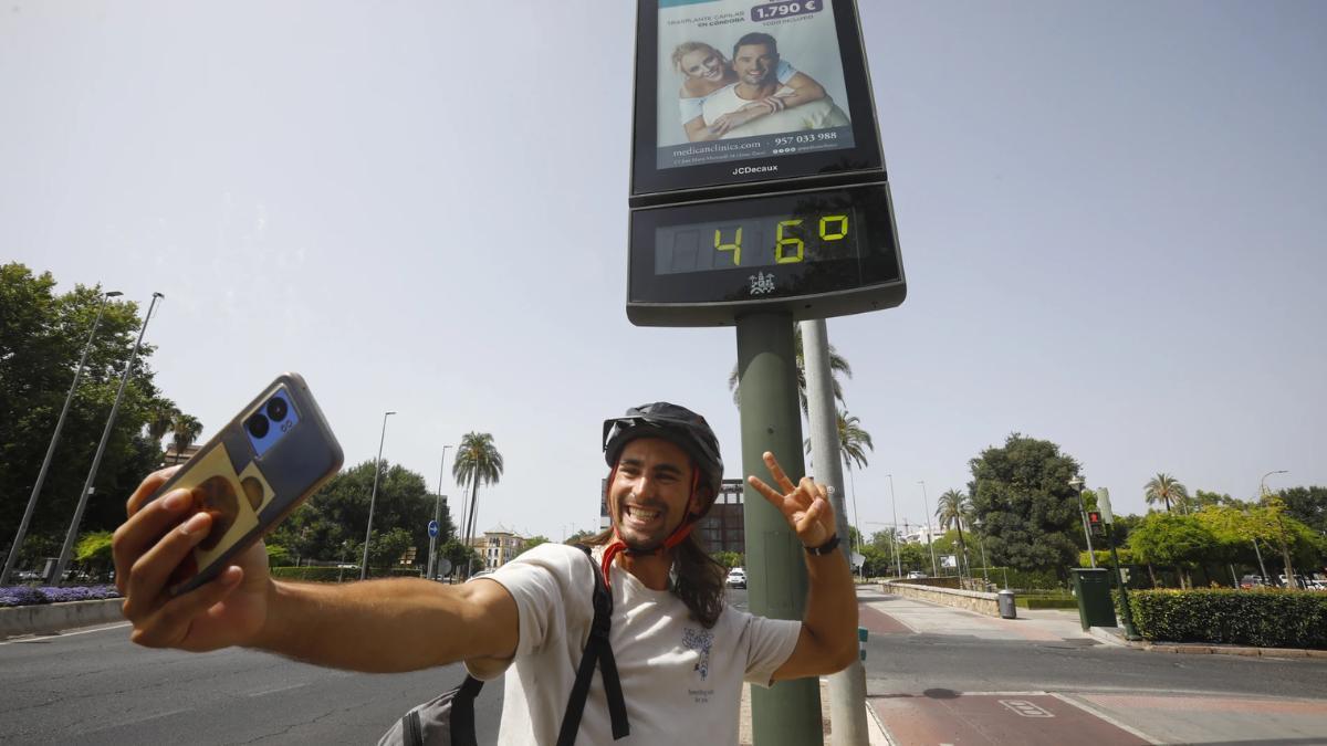 Un hombre posa con un termómetro que marca 46 grados en Andalucía.