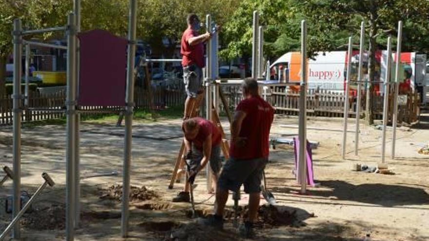 Els operaris muntant els nous jocs al parc infantil de la Font del Ros, dijous