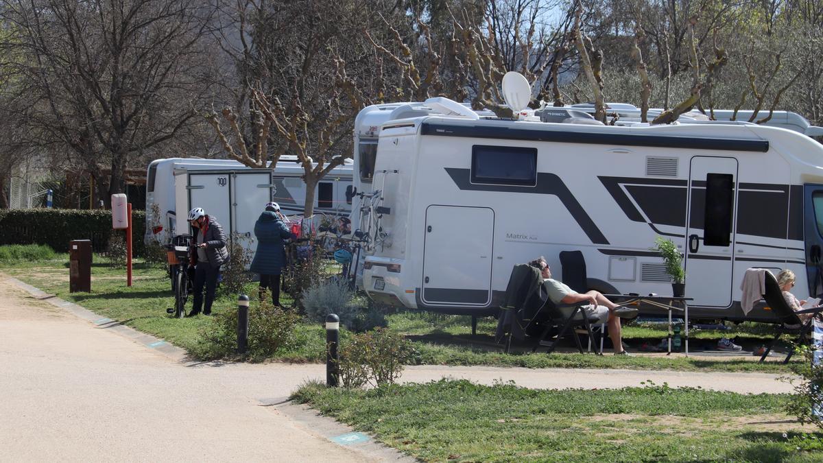 Dos hostes d'un càmping de Roses preparen les bicis mentre que uns altres paren el sol