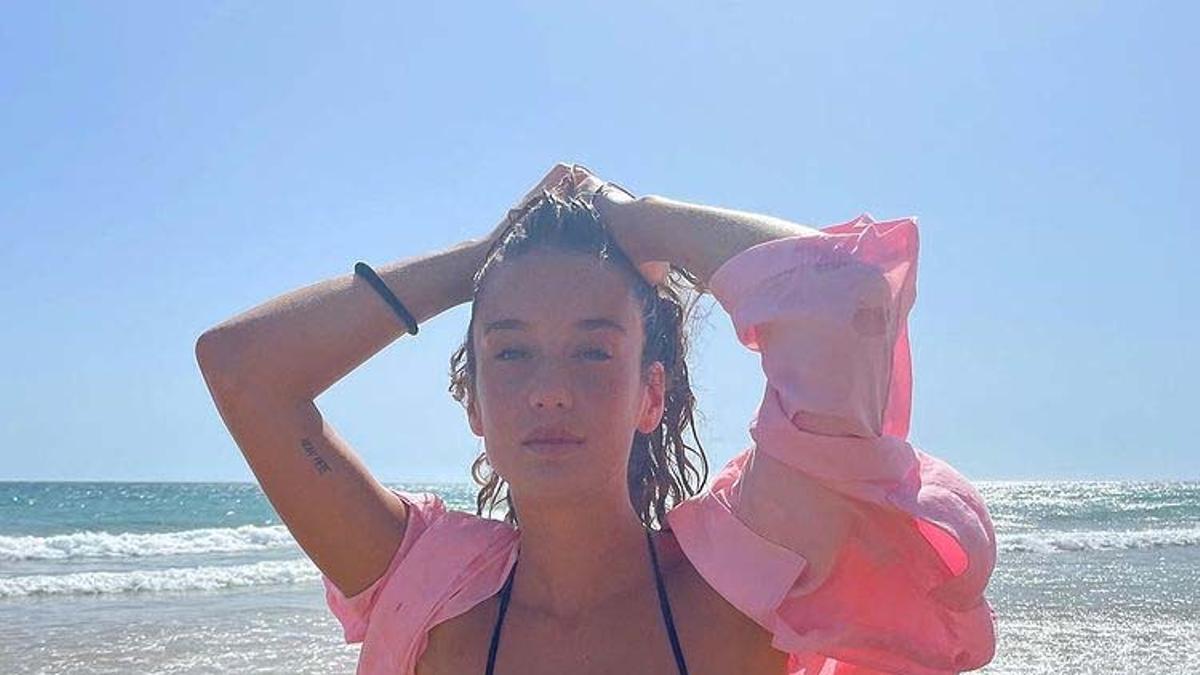 María Pedraza, con bikini negro y camisa rosa, disfruta de su verano en la playa