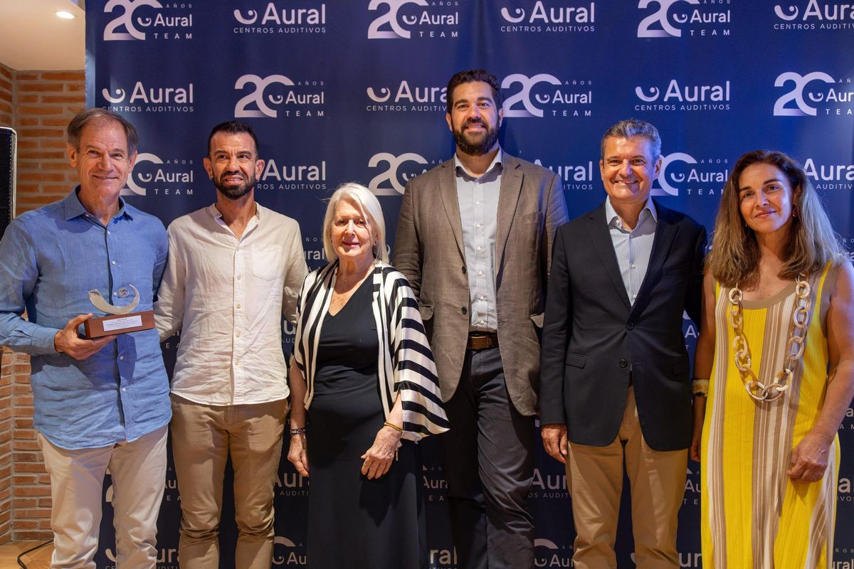 Foto de familia de Abel Antón con miembros de Aural Centros Auditivos y Borja Vivas.