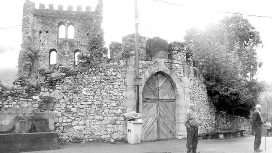 Dos vecinos de la localidad allerana de Soto, junto a la torre medieval.