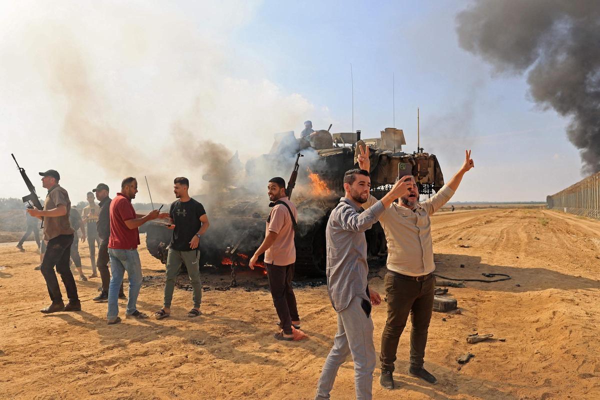 Ciudadanos palestinos se apoderan de un tanque israelí tras cruzar la valla fronteriza con Israel desde Khan Yunis en la parte suroeste de la Franja de Gaza.