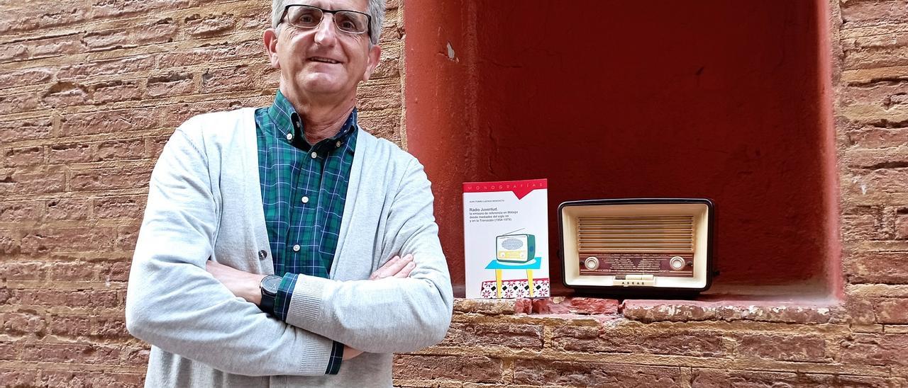 El profesor y periodista Juan Tomás Luengo, junto a su libro sobre la historia de Radio Juventud de Málaga.