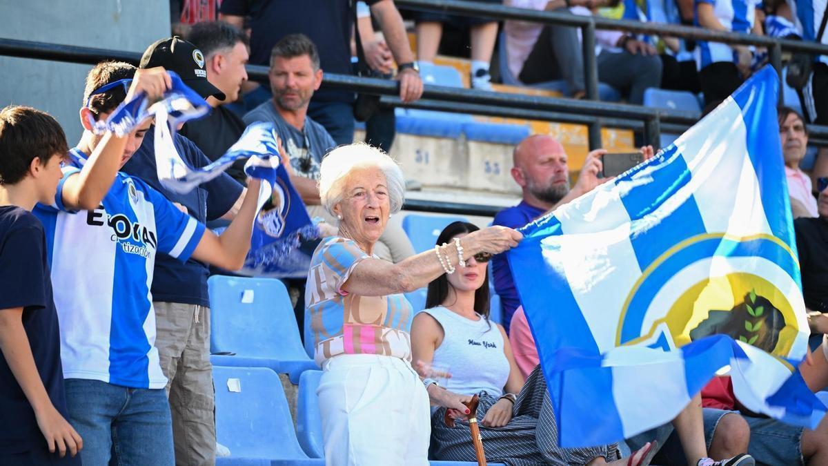 Una aficionada del Hércules ondea la bandera mientras anima a su equipo en la grada del estadio José Rico Pérez.