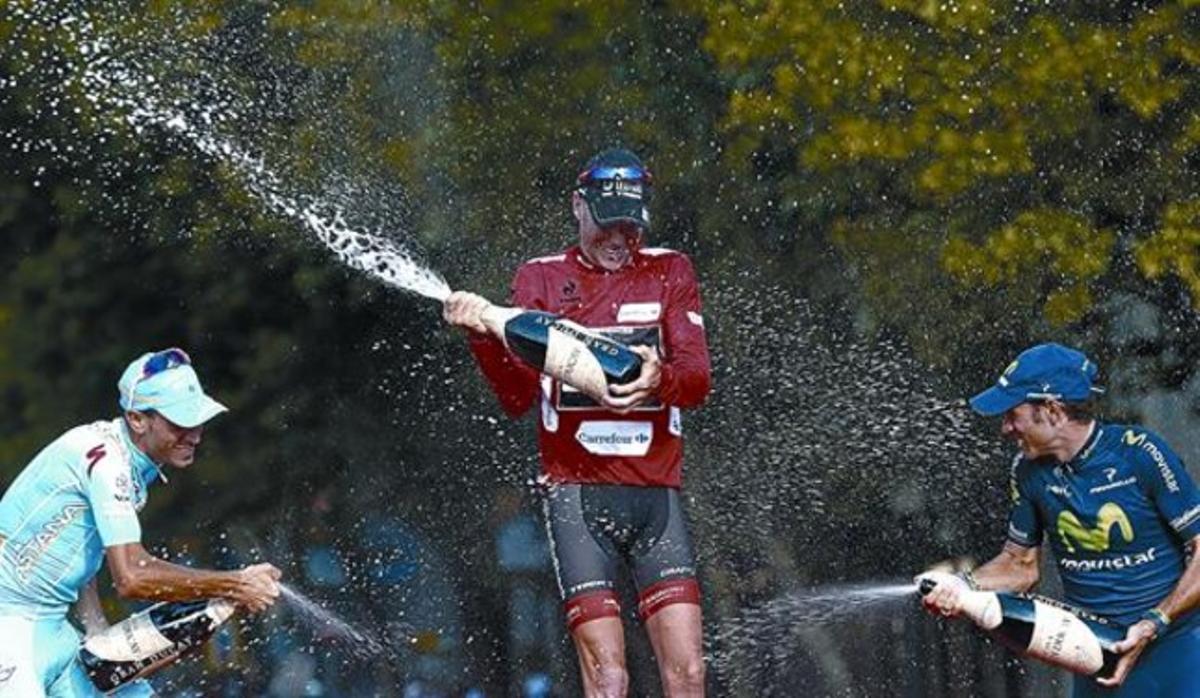 Chris Horner (al centre, de vermell) juga amb el cava, amb Vincenzo Nibali (esquerra) i Alejandro Valverde, ahir a Madrid.