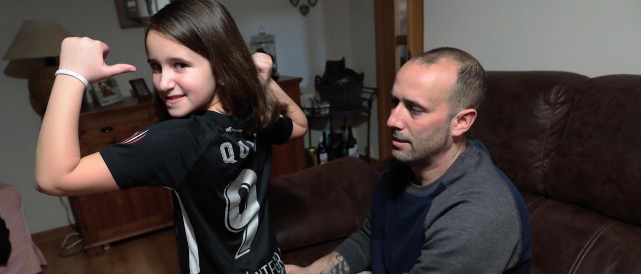 Lola, nieta de Quini, con una camiseta del Sporting junto a su padre, Óscar.