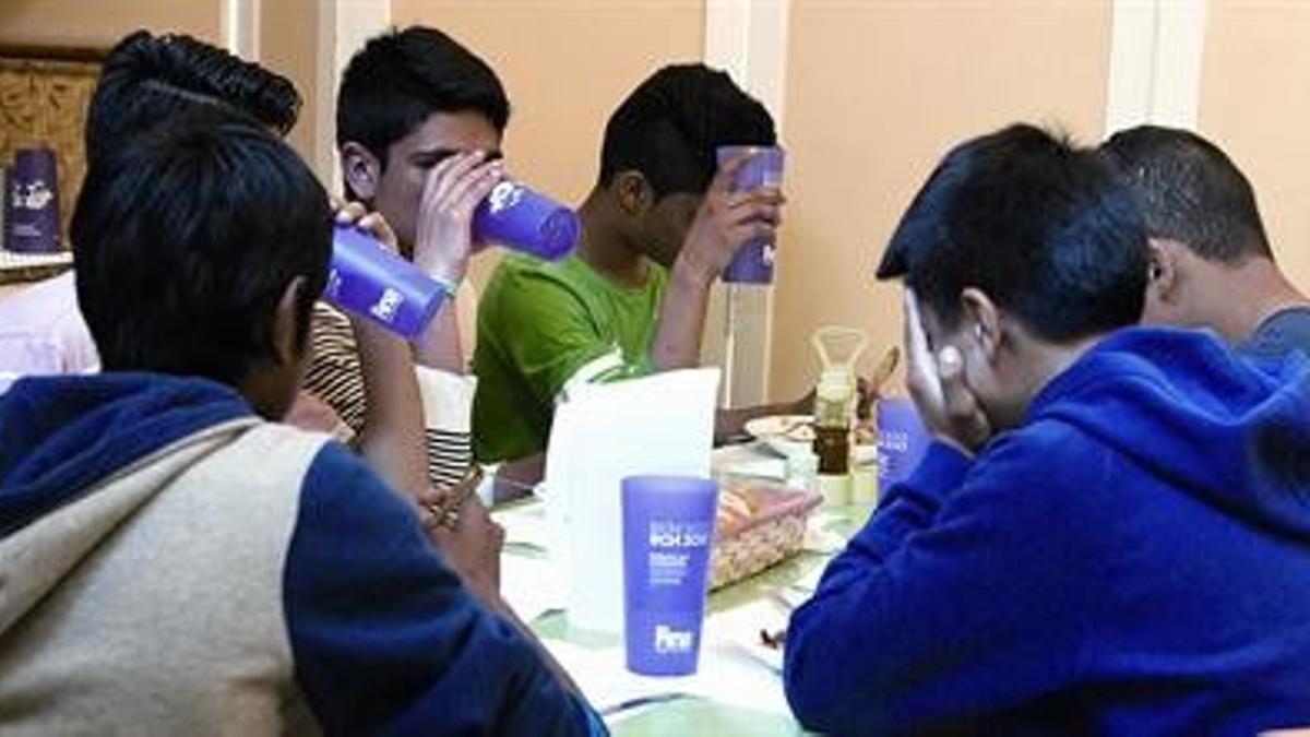 Unos chicos comen en la Associació Educativa Integral Raval, ayer.