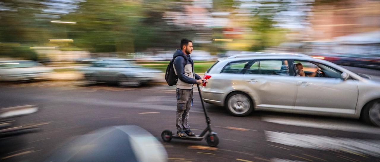 Un usuario de un patinete eléctrico circula por la carretera sin casco.