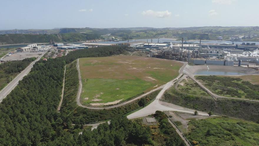 Los terrenos en los que se construirá el gran parque solar, con las instalaciones de Asturiana de Zinc al fondo.