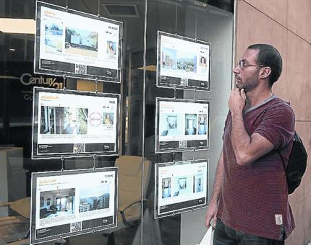 Carteles de pisos en alquiler en una inmobiliaria del barrio de Gràcia.