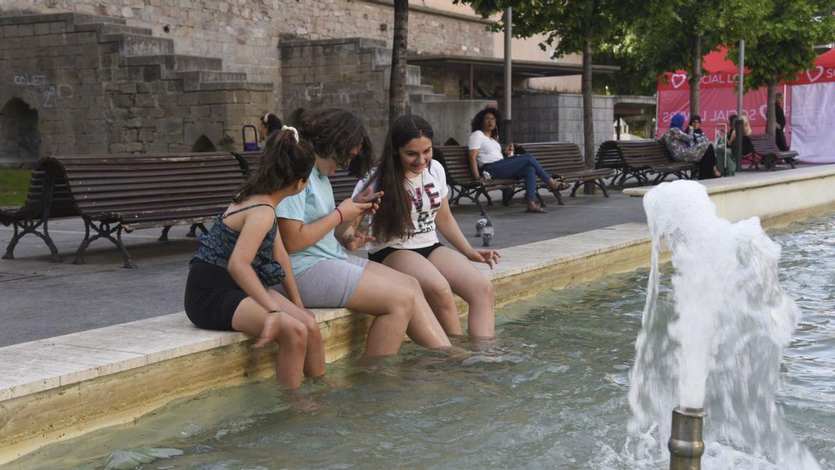 Joves refrescant-se a la plaça Sant Domènec de Manresa | ARXIU/ALEX GUERRERO