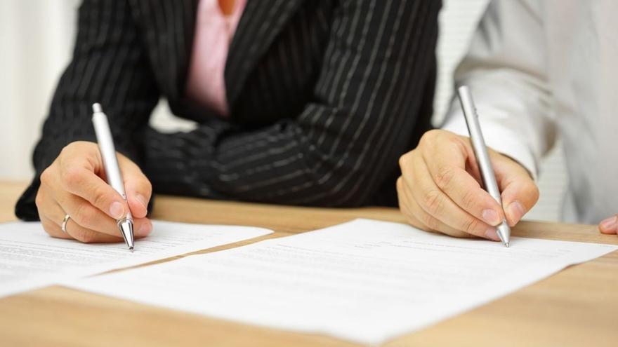 Una pareja firma el acuerdo de divorcio.