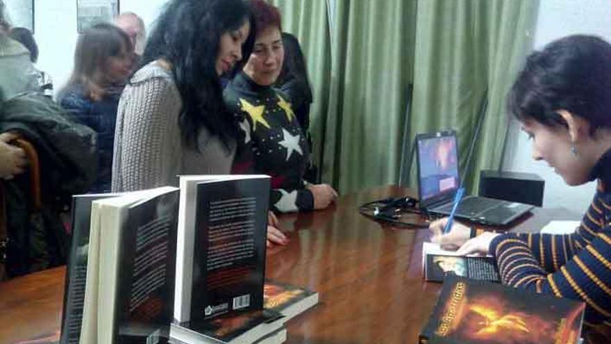 Esther Pablos firma libros durante la presentación.