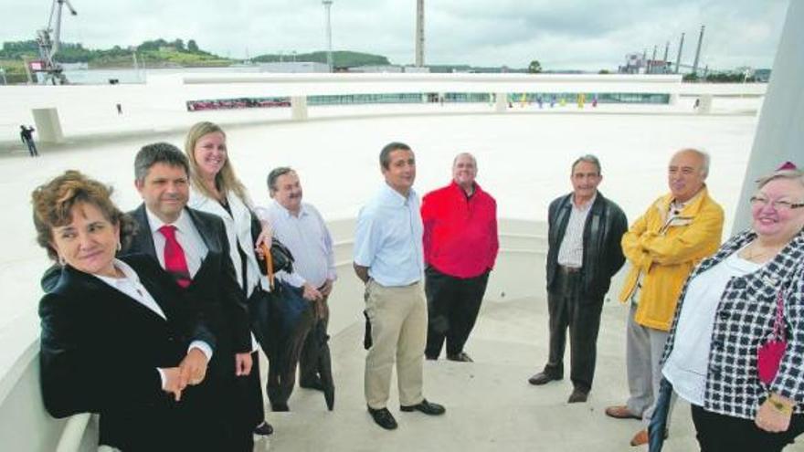 PRESENTE Y FUTURO EN UNA IMAGEN. Marta Elena Díaz, Daniel Couso, Ana Julia López, Antonio Cabrera, David Díaz, Maximino Díaz, José María Olmedo, José María Martínez y Palmira  García, en la escalera de la torre-mirador del Niemeyer, con el polígono industrial de la ría y las baterías de coque de Arcelor al fondo. / ricardo solís