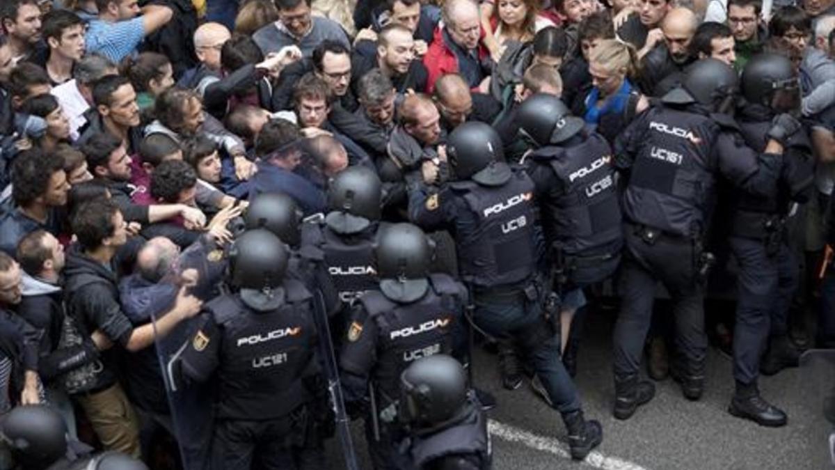 Agentes de la Policía Nacional intenta desalojar a los ciudadanos de la escuela Ramon Llull, el pasado domingo.