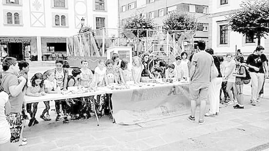 Los niños del campamento en el mercadillo solidario de Cangas.