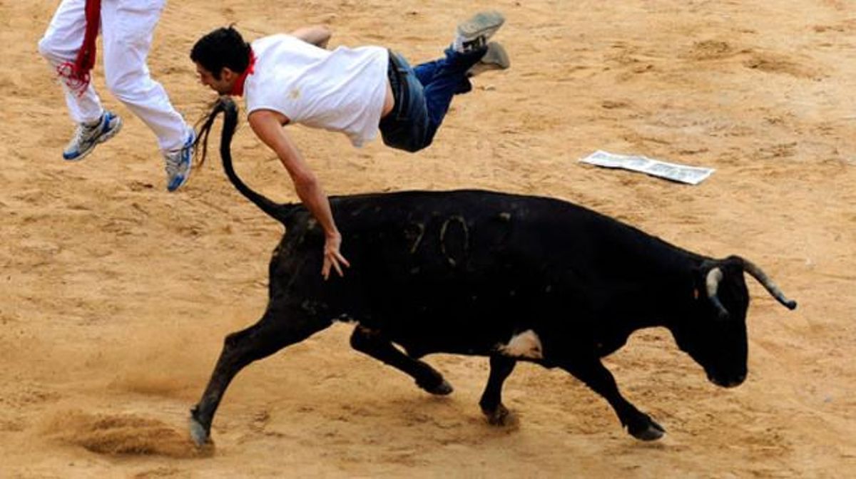 Un toro aixeca pels aires un corredor.